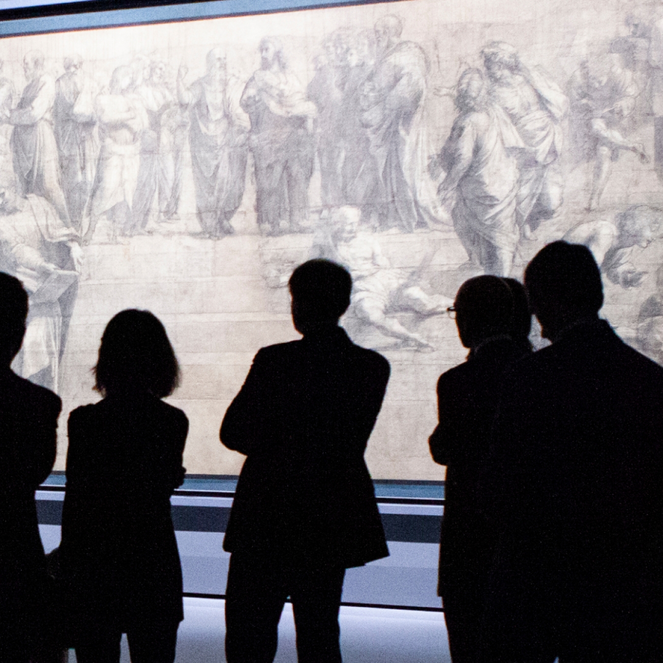 People in the dark in front of an ancient painting People in the dark in front of an ancient painting