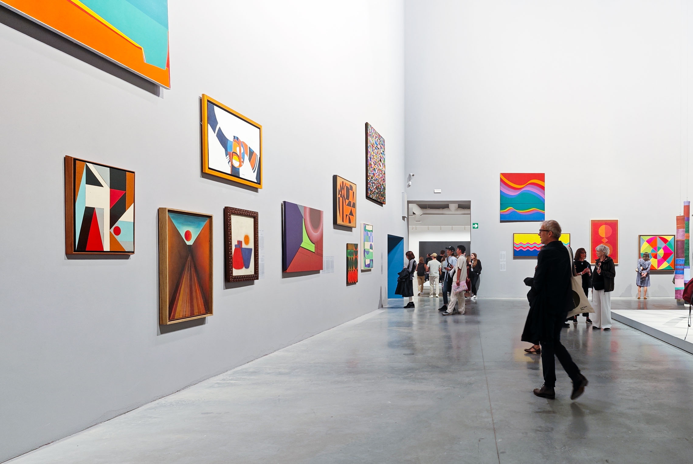 Venice Biennale, visitors admiring paintings in the room dedicated to the abstraction of 37 artists at the central Pavilion inside the Gardens. Venice Biennale, visitors admiring paintings in the room dedicated to the abstraction of 37 artists at the central Pavilion inside the Gardens.
